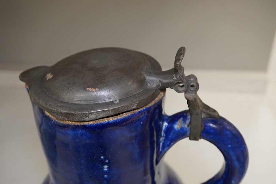 An 18th century German blue glazed faience jug with pewter lid, 30cm. Conditon - poor to fair